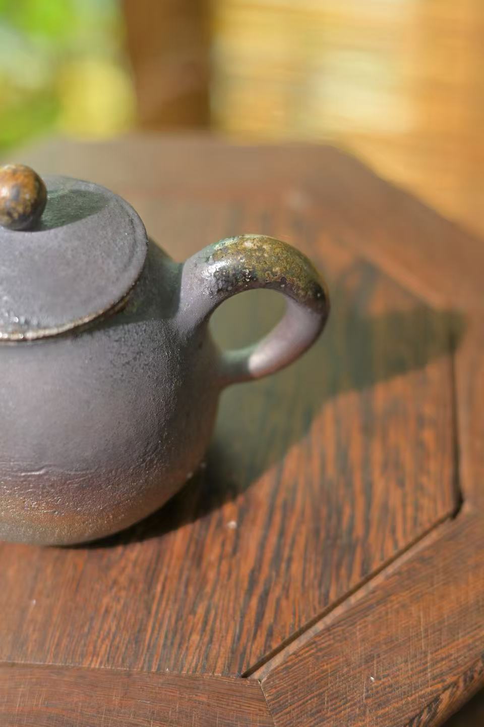 One-of-a-kind Wabi-sabi style stoneware teapot against a minimalist black background.