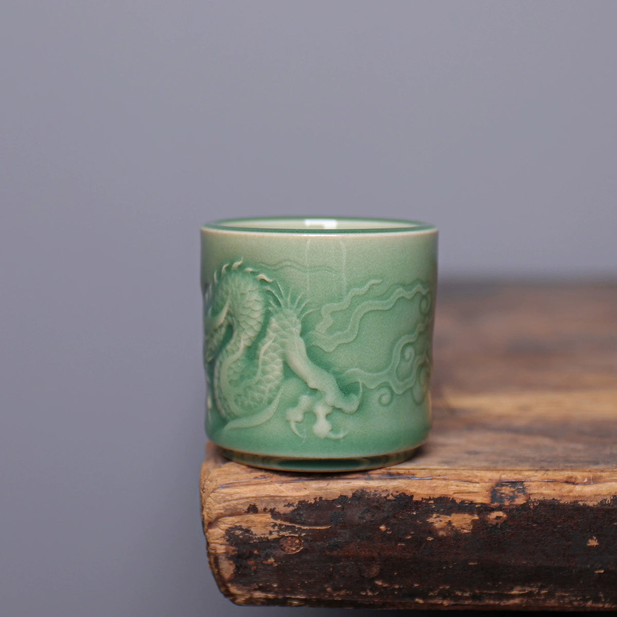 Classical Chinese porcelain master teacup with carved dragon in clouds and plum green glaze