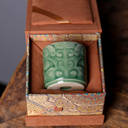 Classical Chinese porcelain master teacup with carved archaic bronze motif and plum green glaze