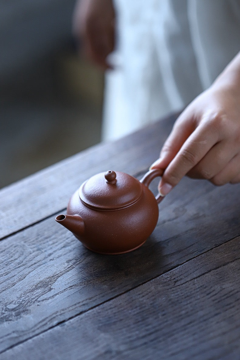 Jiangpo clay teapot with orange-red base and colorful speckles, perfect for roasted Tieguanyin and puerh tea