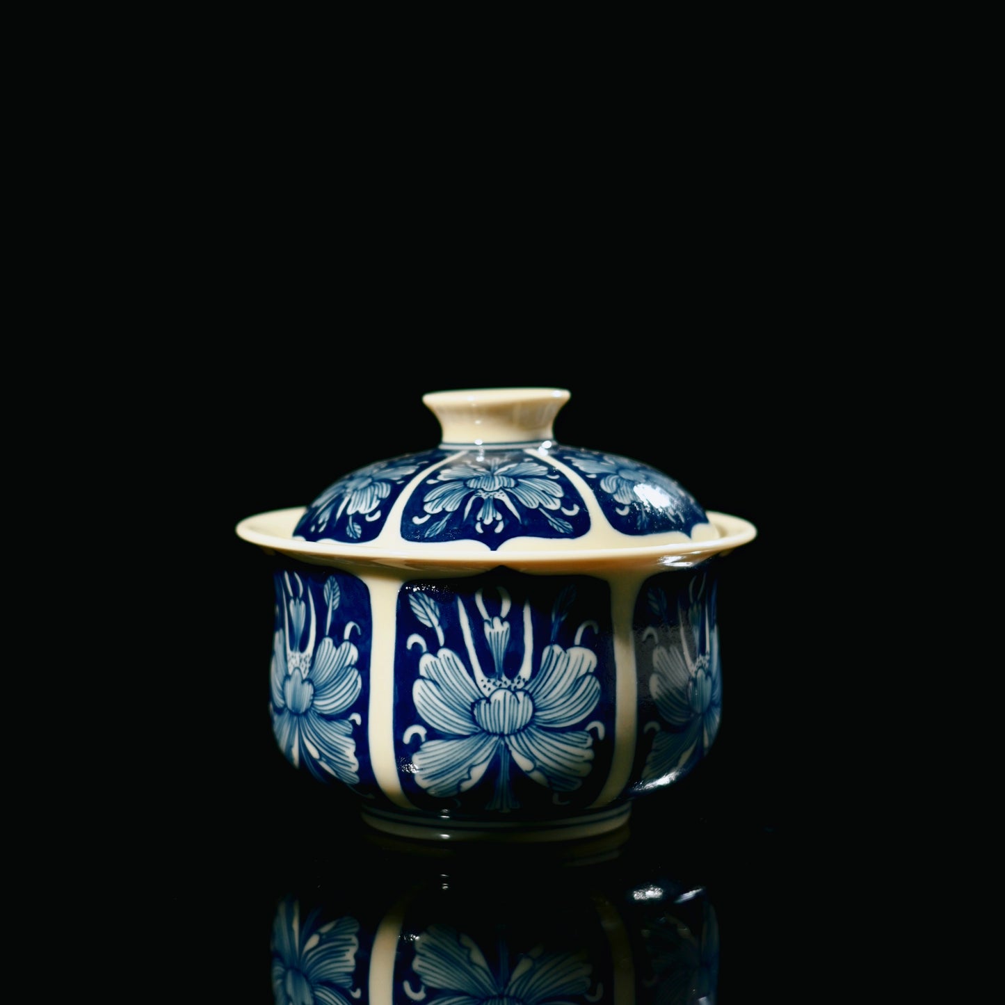 Jingdezhen antique-style gaiwan featuring blue ground decoration with white floral reserved areas
