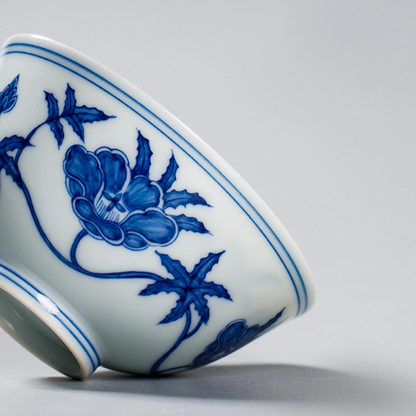 Jingdezhen thin-wall porcelain cup featuring hand-rendered underglaze blue lotus scroll pattern in Ming Dynasty style, showcasing brilliant white glaze and deep cobalt pigmentation.