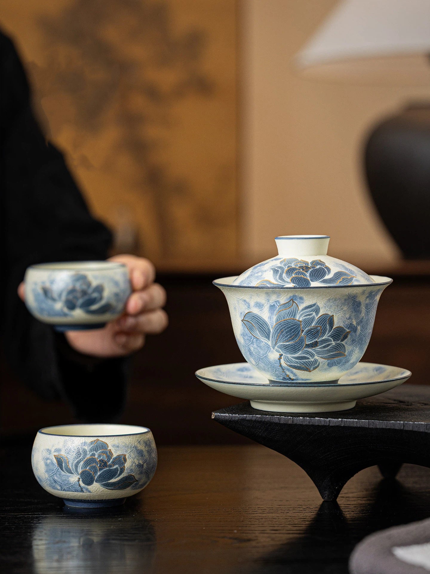 Detailed view of the hand-carved blue and white porcelain teapot featuring a sculpted lid and handle.
