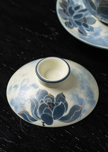 Detailed view of the hand-carved blue and white porcelain teapot featuring a sculpted lid and handle