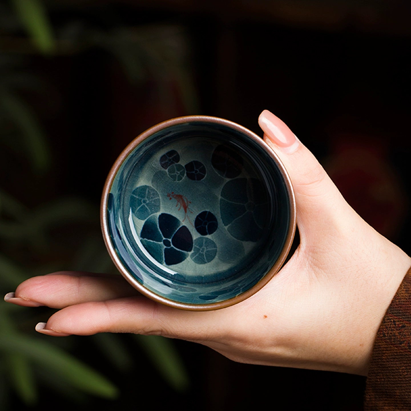 A hand-decorated Jingdezhen blue and white underglaze porcelain tea cup featuring soft cobalt lines beneath a clear glaze, crafted by skilled porcelain artisans.