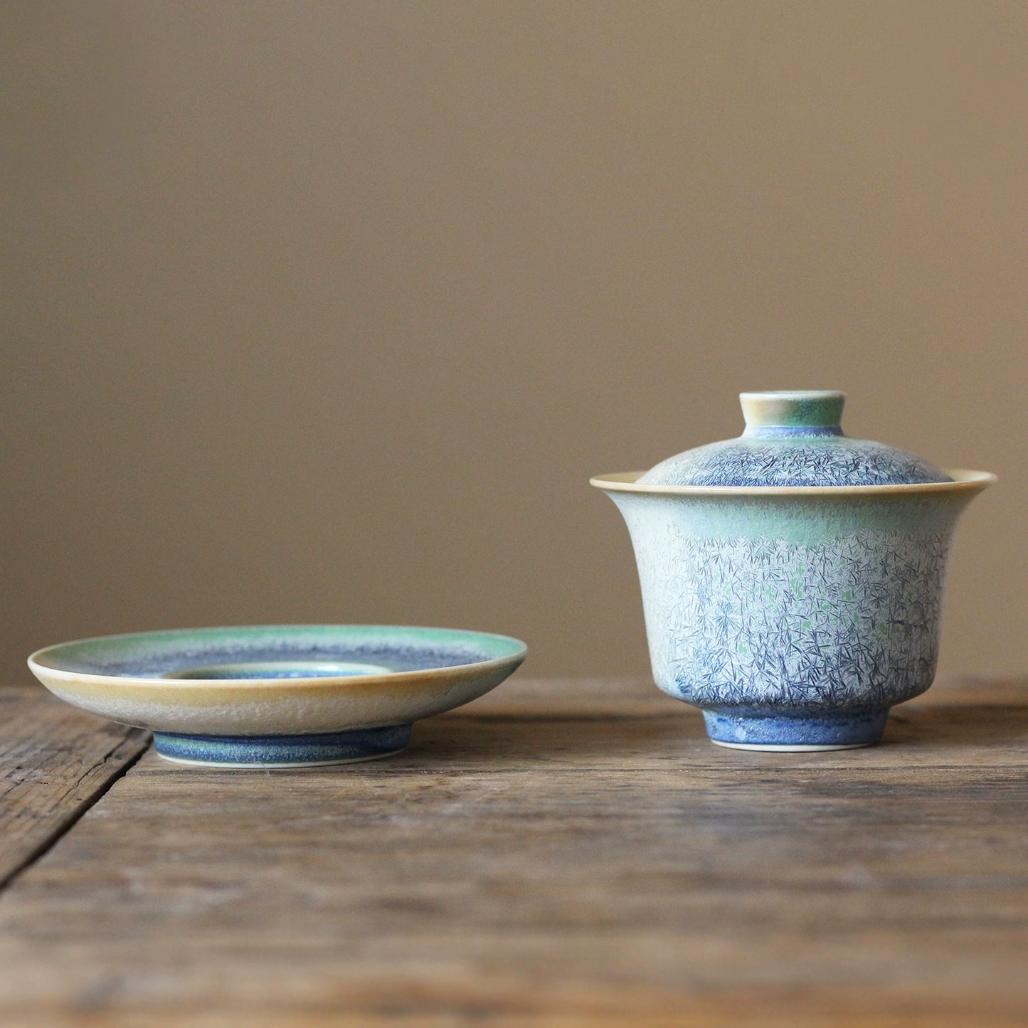 Artisan pine-needle kiln-change gaiwan crafted in Jingdezhen, highlighting unique glaze textures and classic Chinese tea-brewing design.