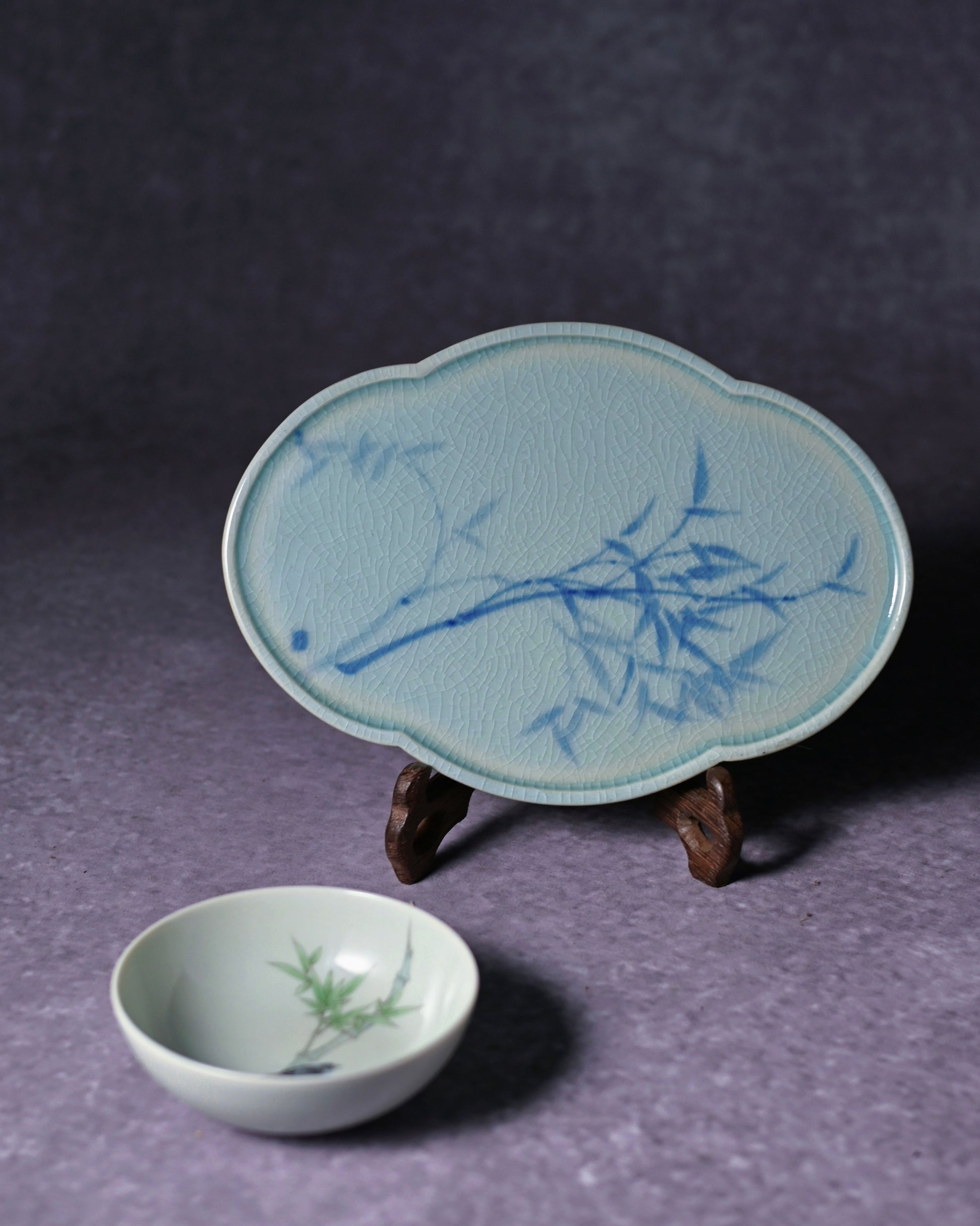 A blue and white tea saucer placed on a traditional tea table, surrounded by a teapot and cups, serving as an elegant decorative piece for a tea space.