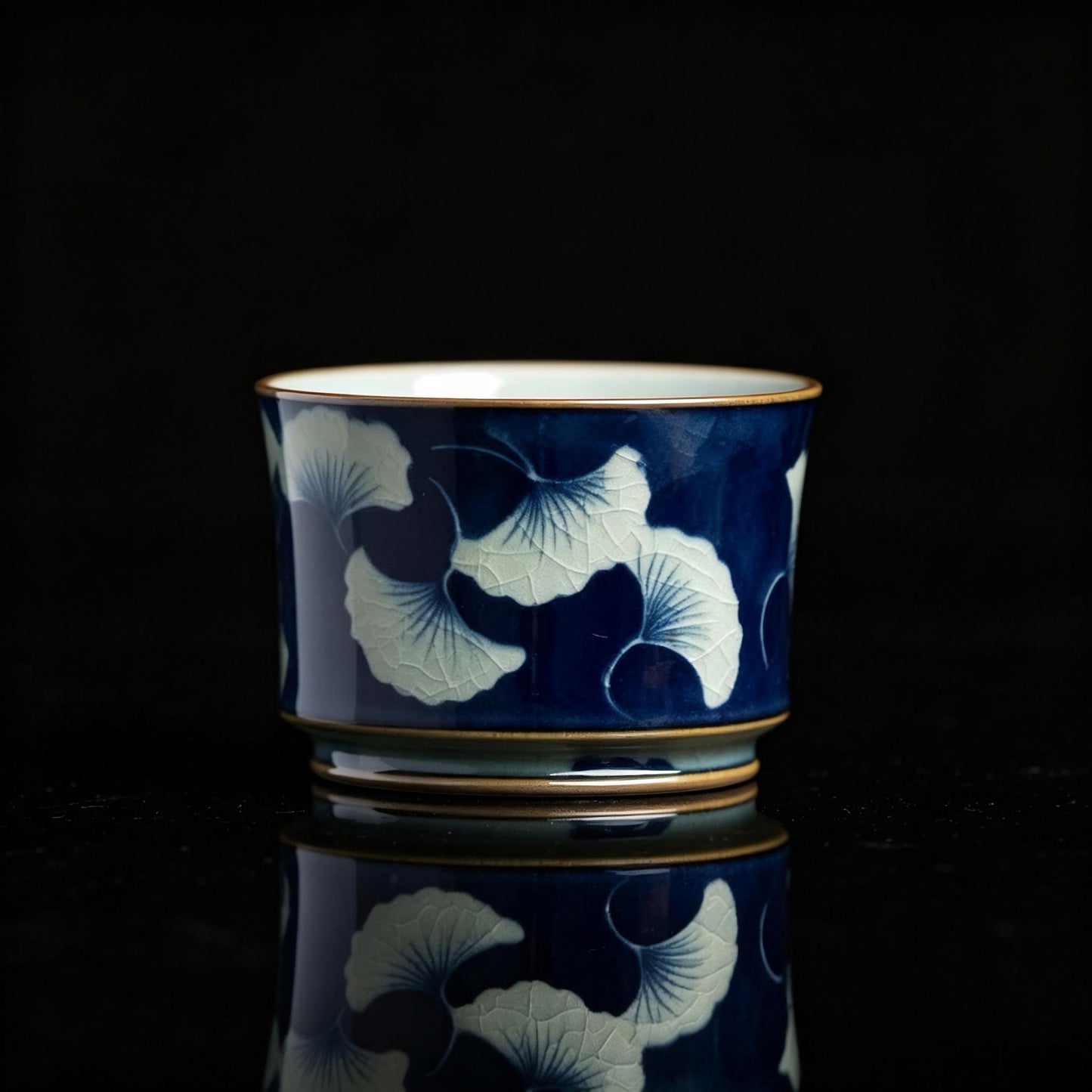 Jingdezhen underglaze‑blue teacup with hand‑painted ginkgo leaves, traditional Chinese ceramic craft
