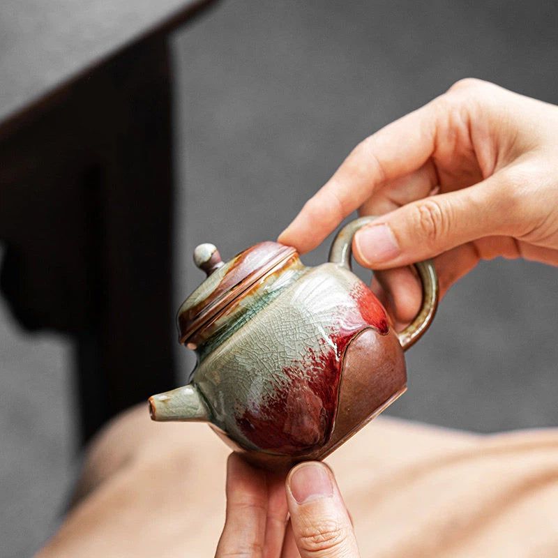 Elegant handcrafted teapot with natural crackle glaze and deep red kiln-fired colors
