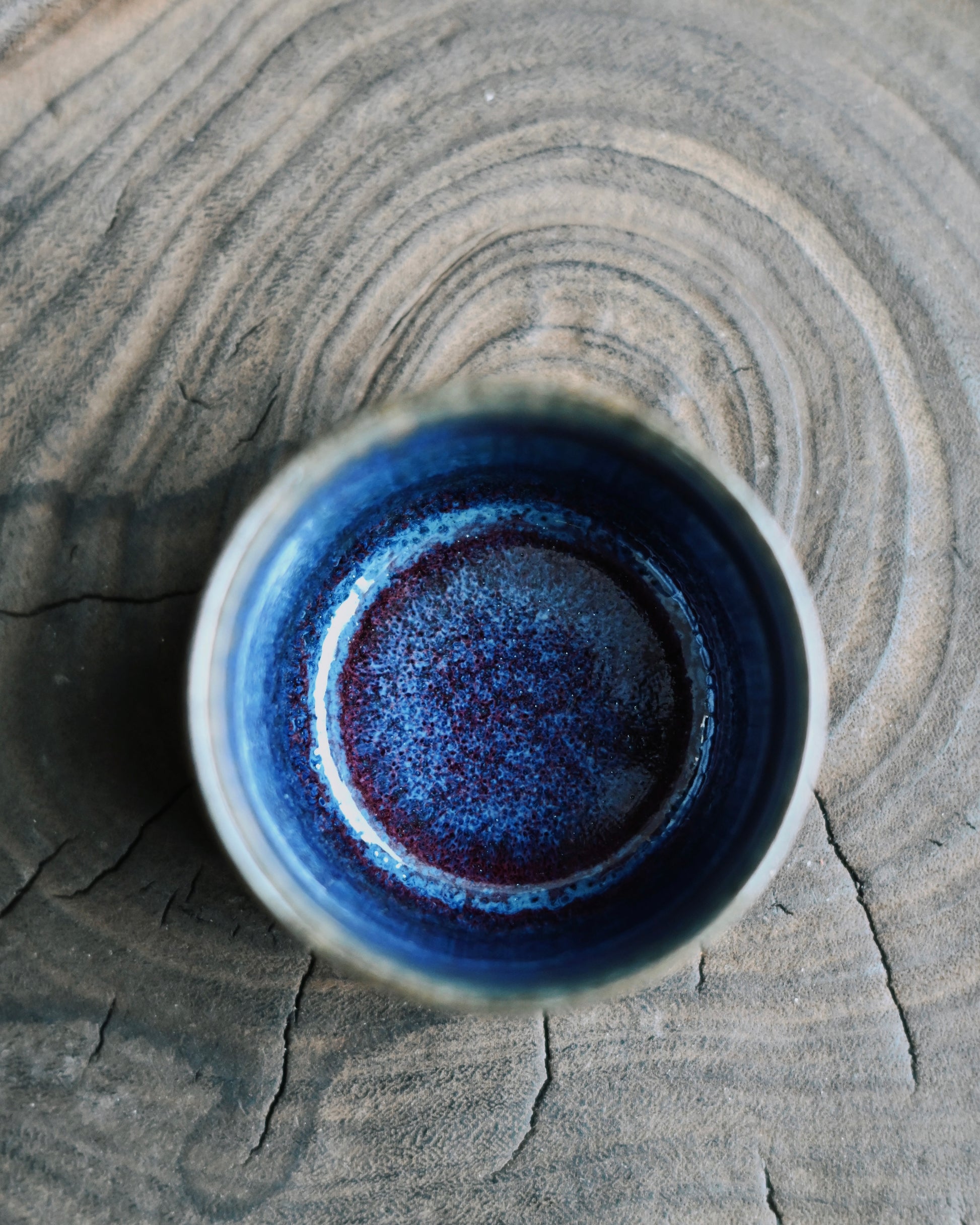Copper and iron infused glaze surface creating deep luminous purple through high-temperature firing