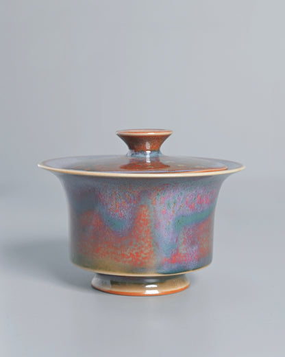 Lavender and oxblood glaze hues blending through spontaneous kiln chemistry reactions