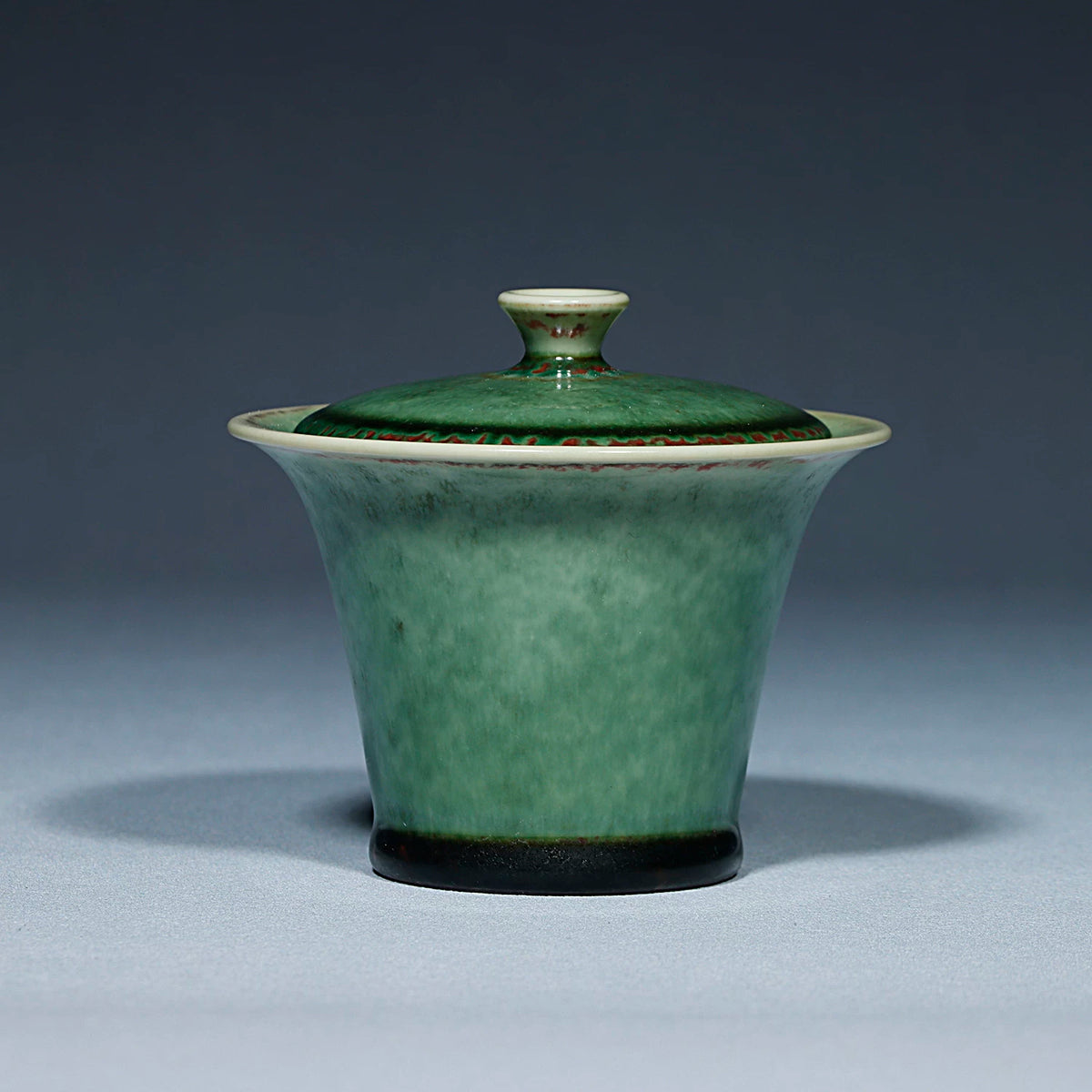 Close-up of the ancient green crystalline glaze and natural kiln transformation on the gaiwan.
