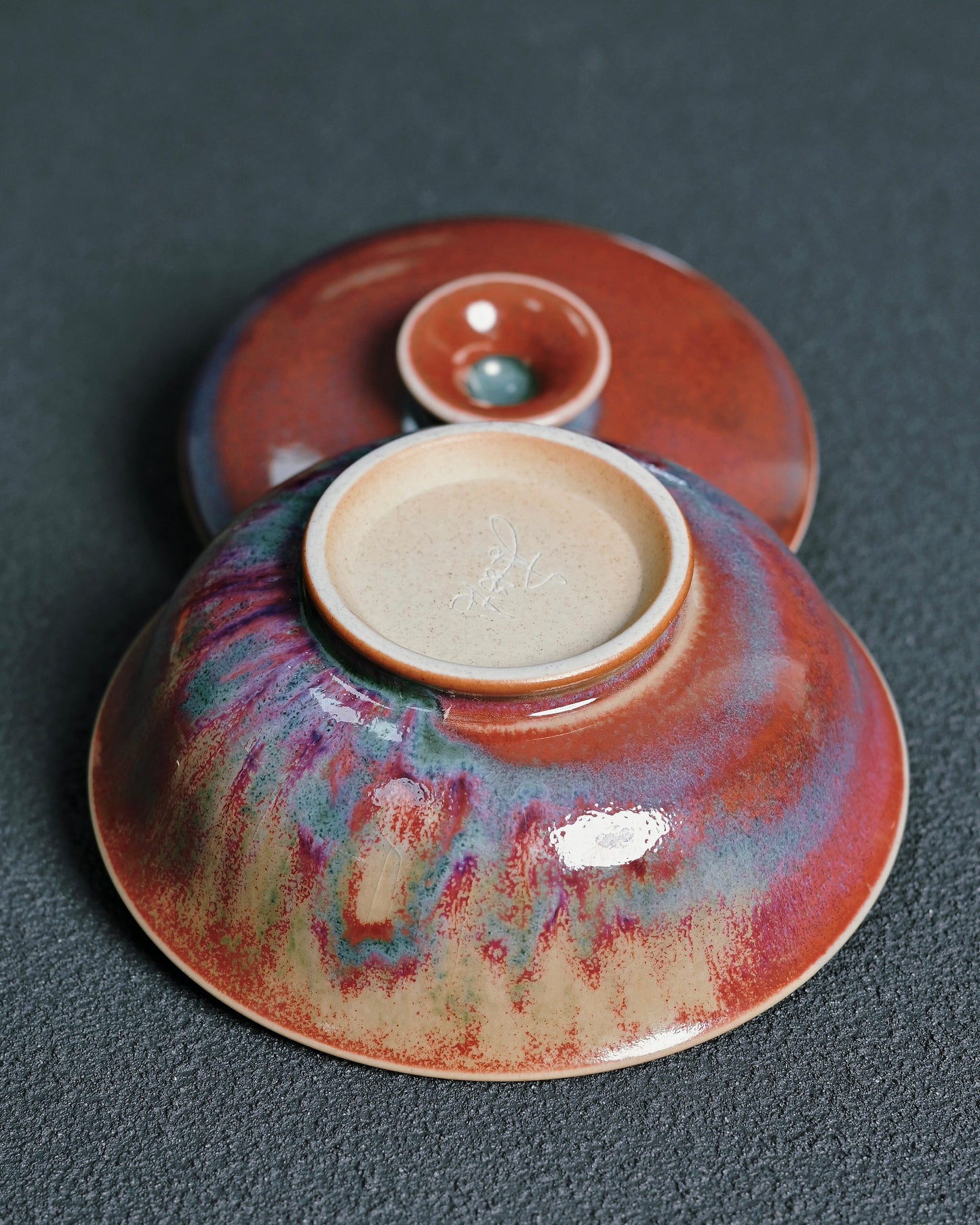 Kiln-transformed Jun ware glaze texture with layered red, purple, and blue tones