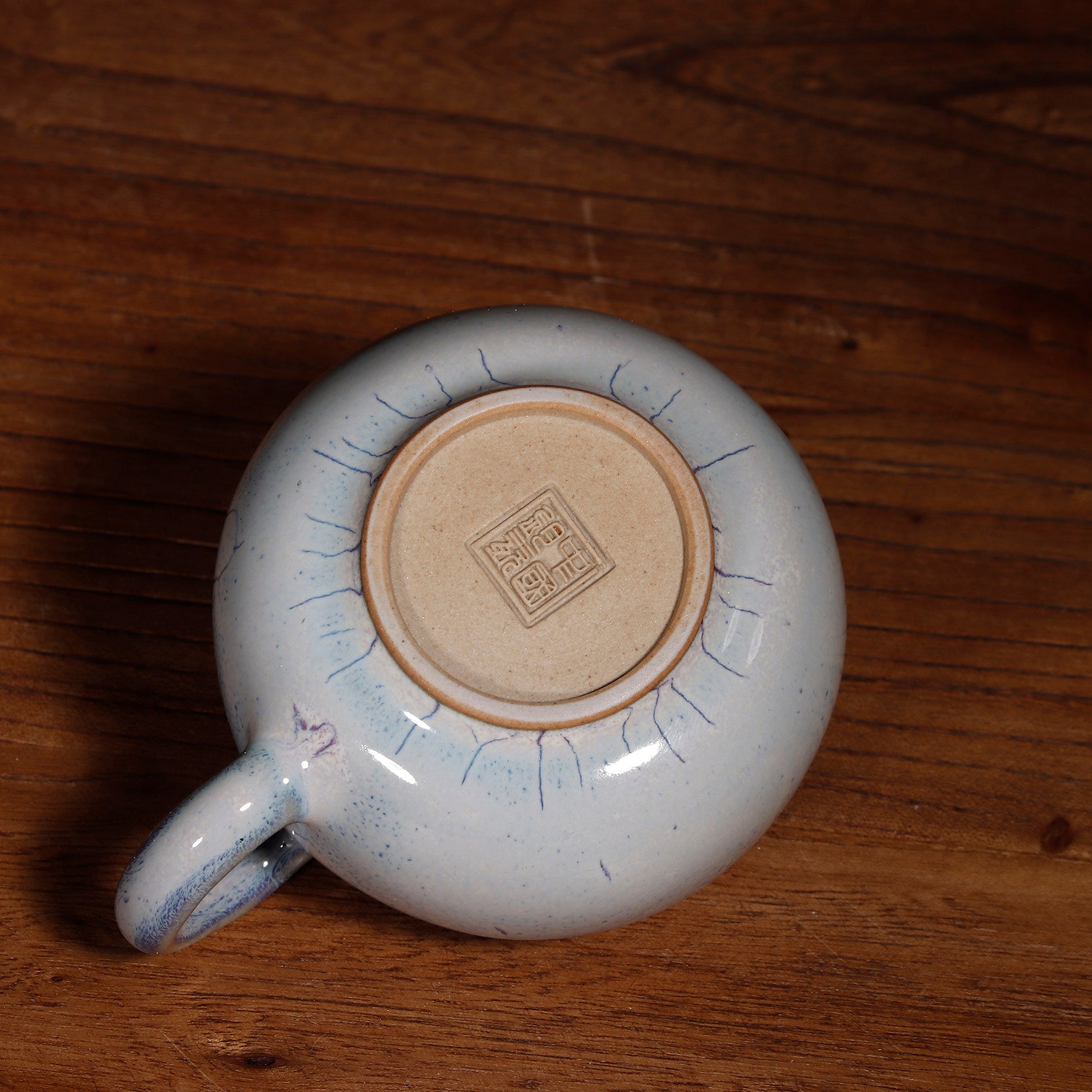 A 100ml Handcrafted Jun Ware Xishi teapot placed on a wooden tea table for a traditional Chinese tea ceremony.