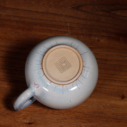A 100ml Handcrafted Jun Ware Xishi teapot placed on a wooden tea table for a traditional Chinese tea ceremony.