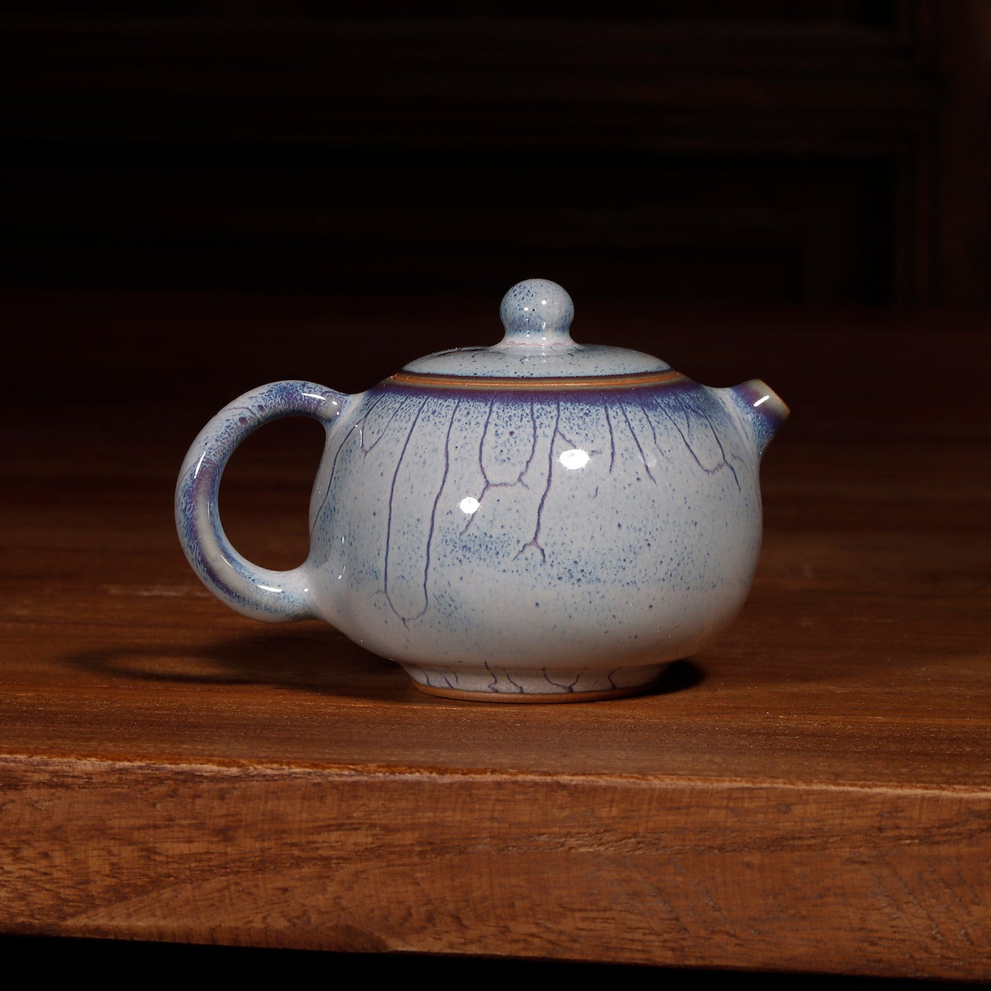 Bottom view of a handcrafted Jun Ware Xishi teapot, showing the unglazed foot ring and artisan mark.