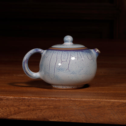 Bottom view of a handcrafted Jun Ware Xishi teapot, showing the unglazed foot ring and artisan mark.