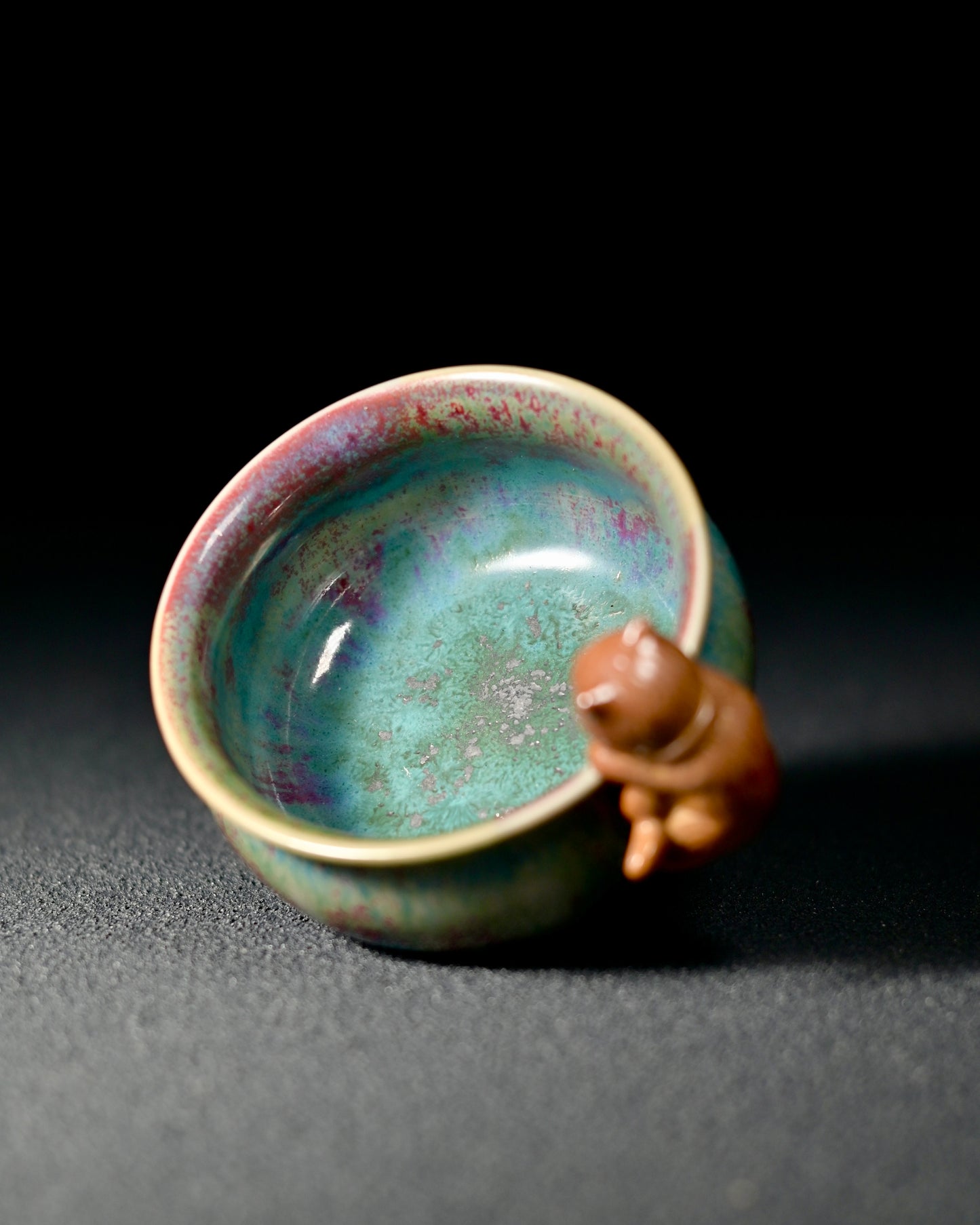 Cat-shaped ceramic handle adding playful elegance to functional tea drinking vessel