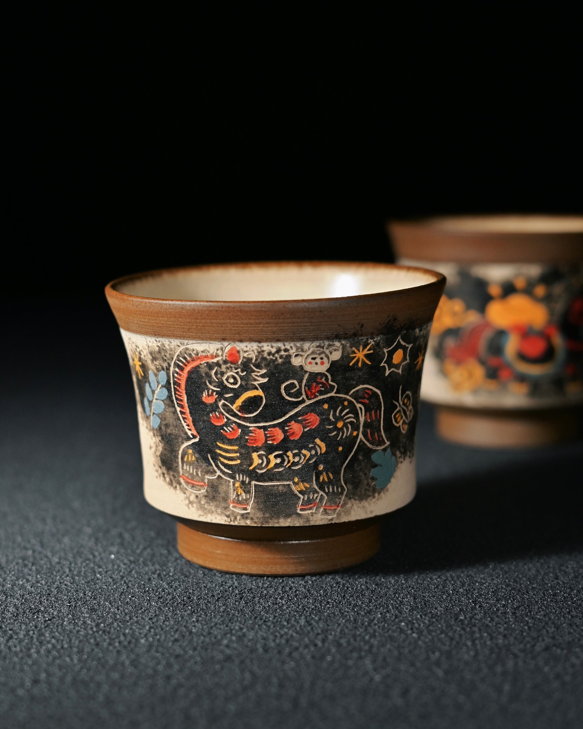 Knife-carved outline detail creating three-dimensional effect in the painted pony design on ceramic teacup surface