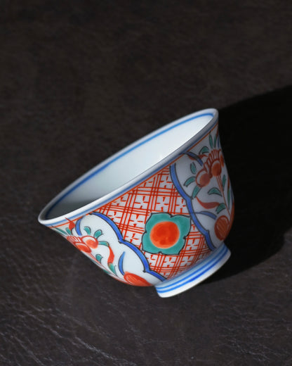 Kutani tea cup showing white plum blossoms and autumn leaves painted in delicate overglaze enamel.