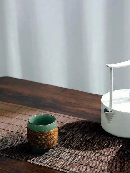 Yuanrong rounded Longquan celadon teacup crafted with Sichuan hand‑woven bamboo sleeve, oriental tea utensil