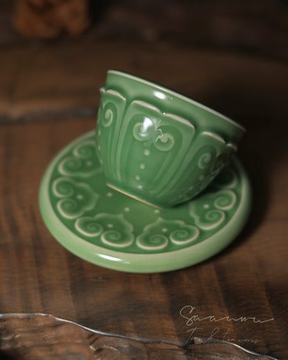 Traditional Chinese tea cup and saucer made of Longquan celadon with detailed hand-carved Baoxiang pattern.