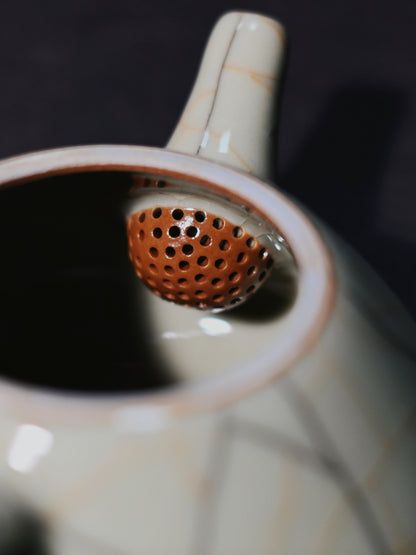 Longquan celadon Ge Kiln Shipiao teapot with crackled glaze in creamy beige, fully handcrafted from iron-rich clay, delivering perfect pouring precision