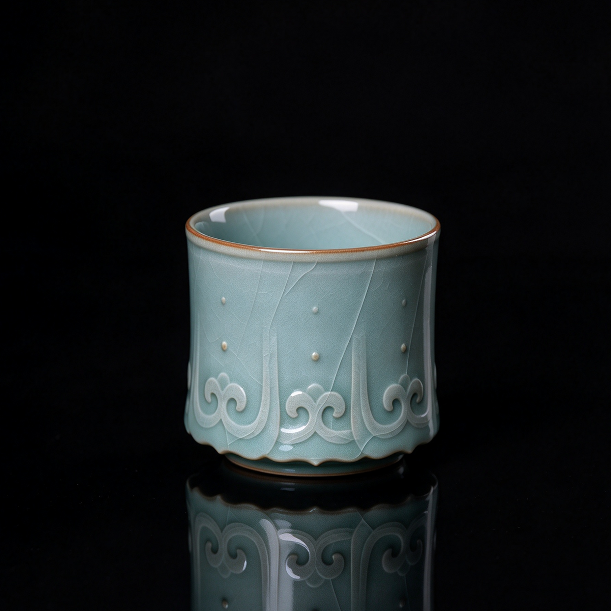 Longquan Celadon Ge Kiln embossed relief teacup with jade crackle glaze resting on rustic wood