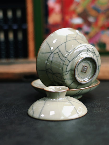 Saanwu Studio iron-bodied horseshoe gaiwan in Longquan celadon with golden crackles, traditional Sancai form, and functional design for tea connoisseurs.