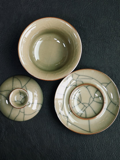 Handcrafted Longquan celadon Sancai gaiwan featuring Ge-style 'golden thread and iron wire' crackles, iron-rich clay construction, and efficient pouring design for various tea types.