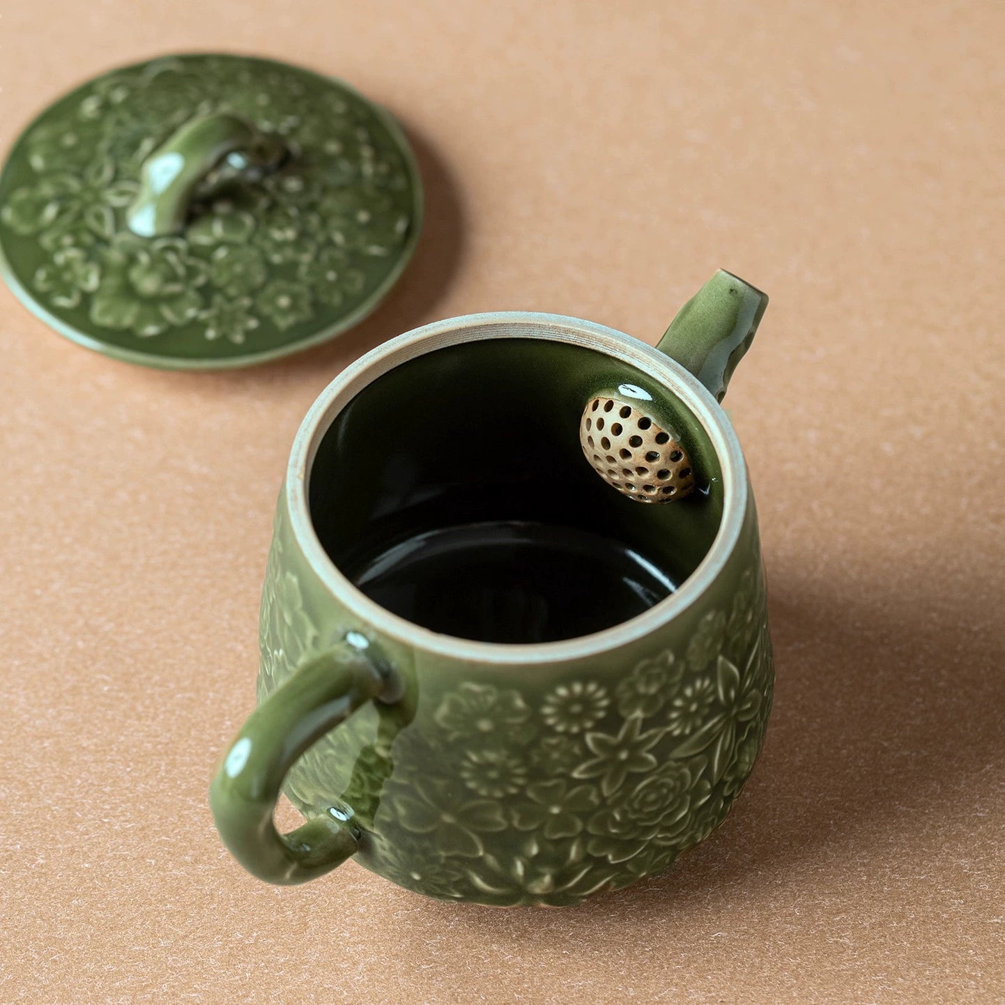 Detailed relief-carving on handmade celadon teapot