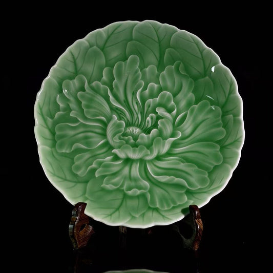 Longquan Celadon High-Relief Carved Peony Tea Saucer in a front studio shot.