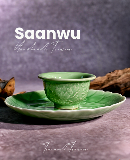 Longquan Celadon High-Relief Carved Peony Tea Saucer set on a wooden tea tray for a Chinese tea ceremony.