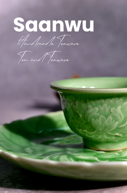 A celadon teacup resting on the Longquan Celadon High-Relief Carved Peony Tea Saucer.