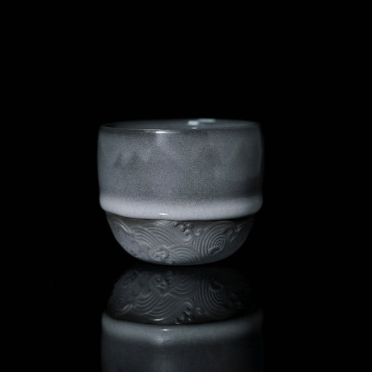 Longquan celadon iron-grey tea cup with thick glossy glaze and hand-carved wave pattern on lower section