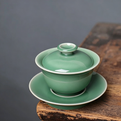 Plum-green Meiziqing celadon gaiwan with matching saucer showing smooth unctuous glaze depth