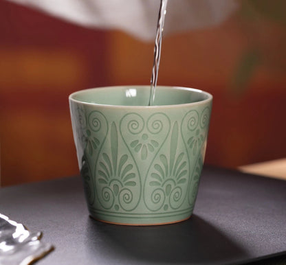Clear tea soup poured into the Longquan Celadon Plum Green Relief Carved Cup for Gongfu tea session.