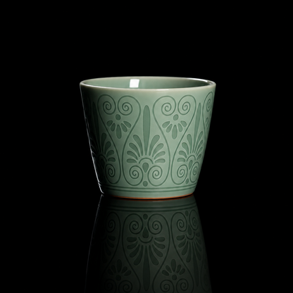 Longquan Celadon Plum Green Relief Carved Coffee & Tea Cup in a front studio shot.