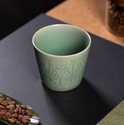 Macro view showing the deep plum green glaze pooling over the relief carved details.