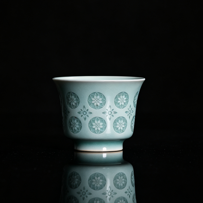Handcrafted Longquan celadon horse-hoof teacup in powder green glaze with translucent pierced floral Linglong motif