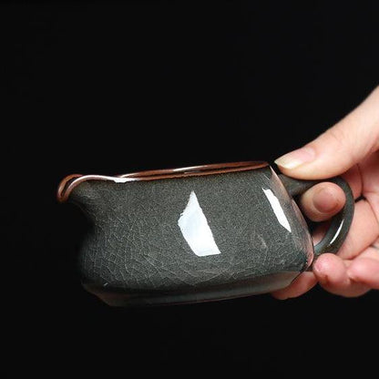 Glossy Longquan celadon tea vessel showing metallic-gray tone and delicate crackle network.