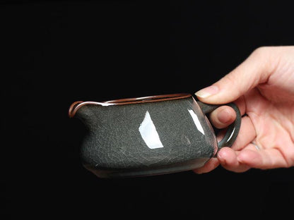 Iron-bodied celadon Gongdao Bei featuring a smooth, reflective glaze with fine crackles.