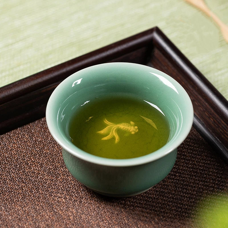 Artisan Longquan Celadon Porcelain Teacup with Koi Fish Relief Design, Highlighting Exquisite Craftsmanship and Timeless Oriental Aesthetic.