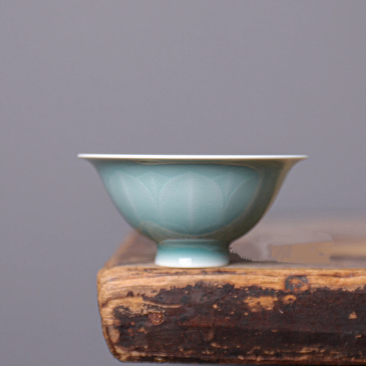 Close-up of the sculpted lotus petal relief pattern wrapping around the Longquan Celadon cup.