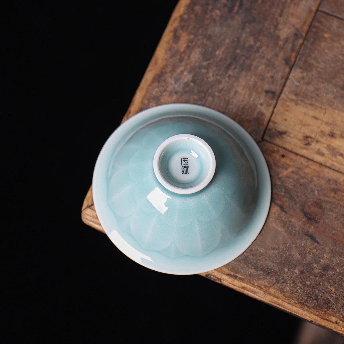 Side profile highlighting the sculpted lotus petal shape of the Longquan Celadon tea cup.