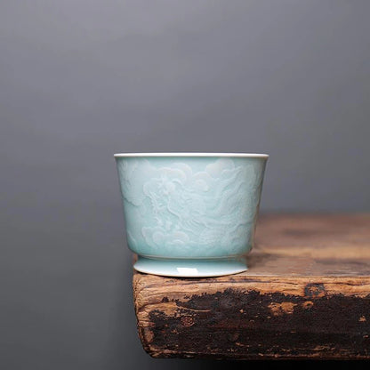 Side profile of the Longquan Celadon tea cup showing the play of light and shadow across the relief carving.