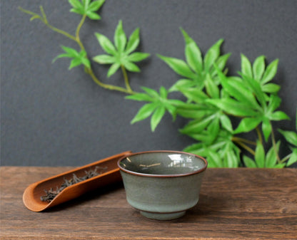 Longquan celadon teacup with iron-gray body and Ge kiln-style glossy crackle glaze.
