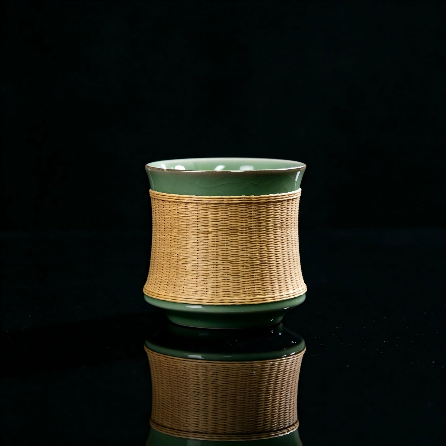 Main product shot of Longquan Ge‑Yao celadon teacup with hand‑woven bamboo sleeve, plum‑green crackle glaze, black background with mirror reflection