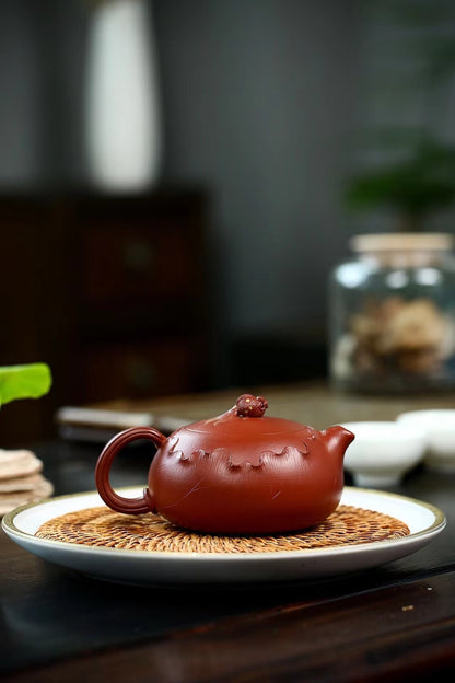 Flattened Xishi teapot showcasing hand-carved lotus artistry, Yixing's legendary clay, and hydraulic engineering for perfect tea preparation.