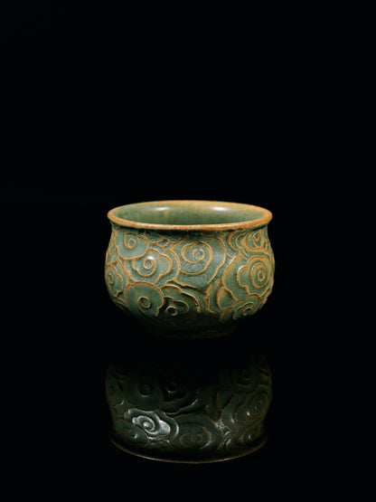 Yixing zisha teapot set with hand-carved cloud relief pattern in green glaze, fully handcrafted for gongfu tea.